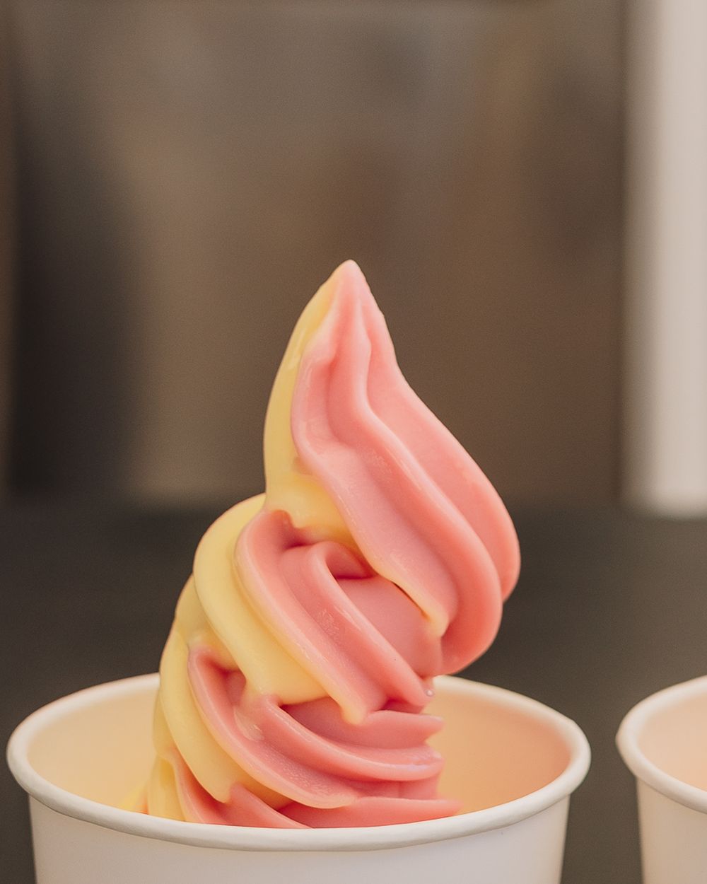 Two pink and yellow Dole Whip swirls in cups